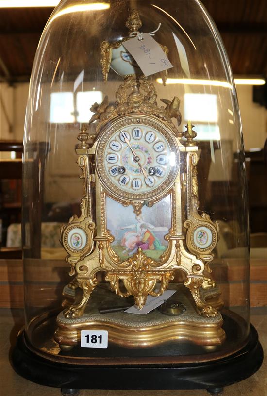 A French gilt metal and porcelain mounted mantel clock, glass dome